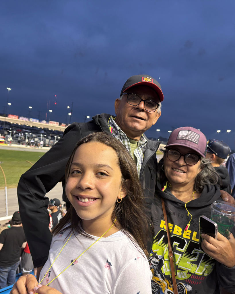 Grandparents with their grandchild outside at a racetrack