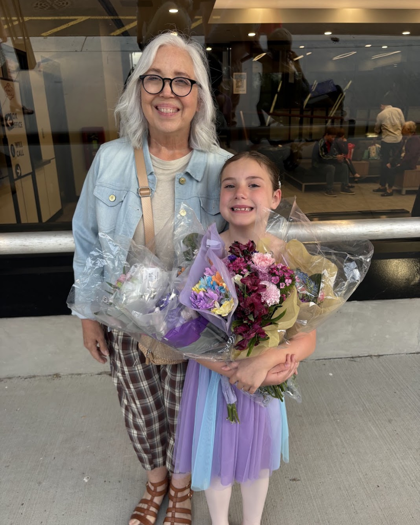 Grandma with her grandchild after her dance recital, with flowers