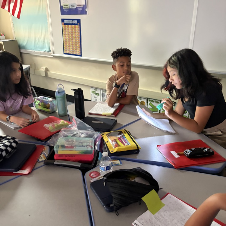 Students enjoying reading and writing in the dark with a flash light. 