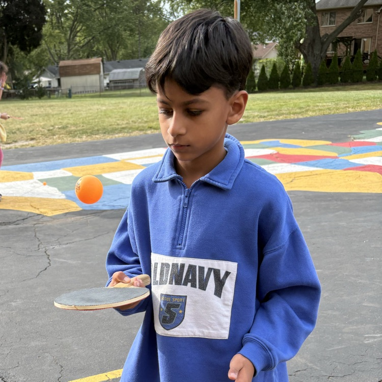 a boy bouncing his ping pong ball on his paddle