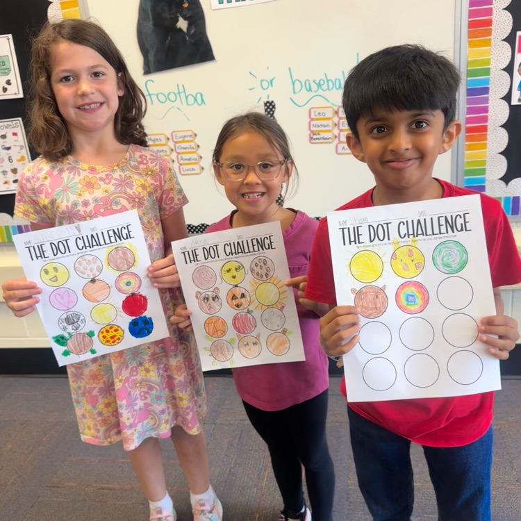 three students showing their Dot Day artwork 