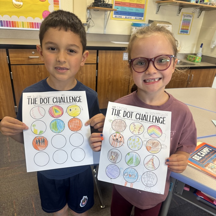 two students showing their Dot Day artwork 