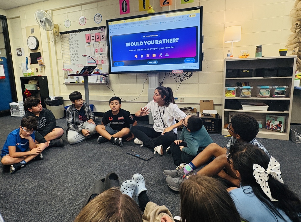 Students sit in circle with teacher