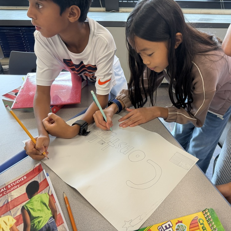 two students working on poster 