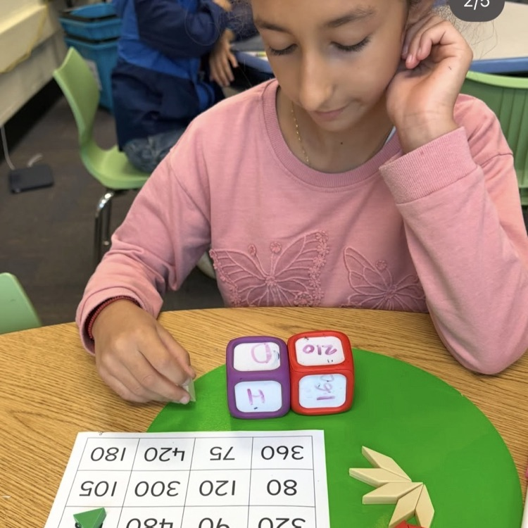 student working with dice and pattern blocks to mark numbers