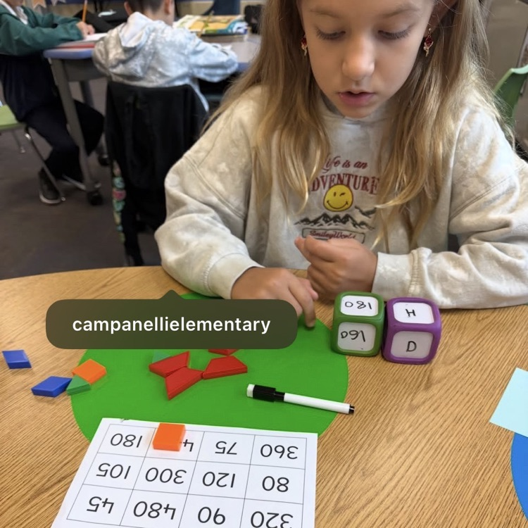 student working with dice and pattern blocks to mark numbers