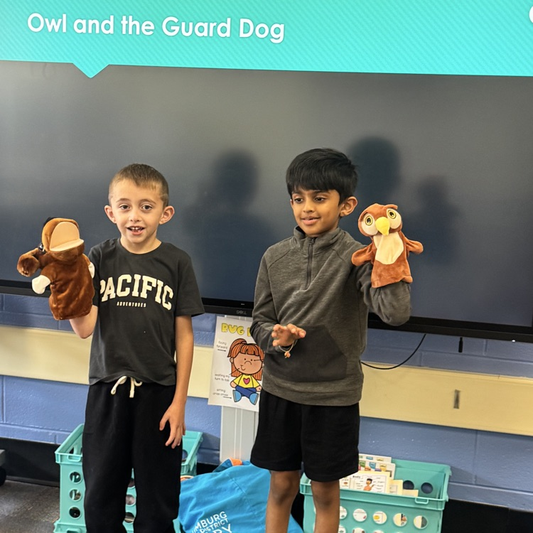 two students holding owl and dog