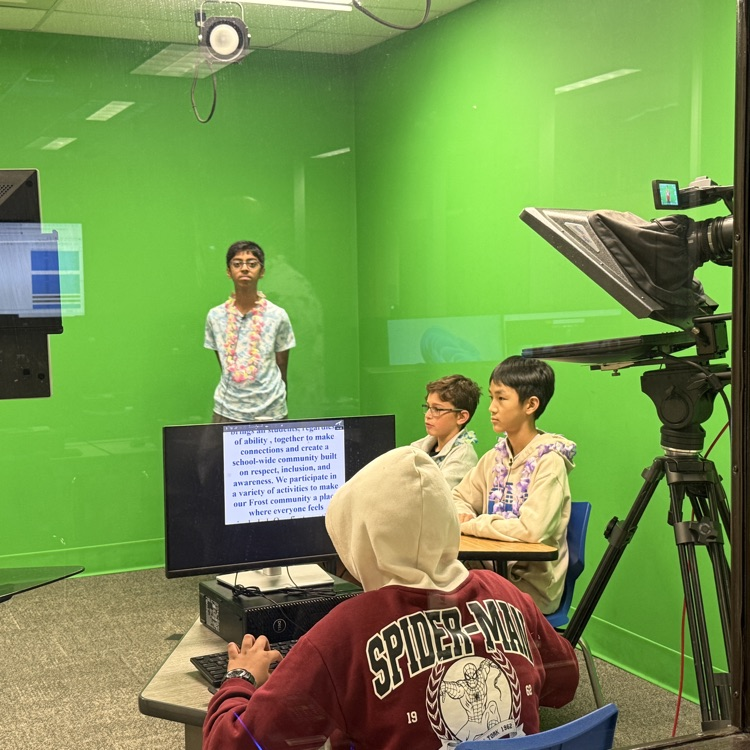 students sitting at a desk in a green room