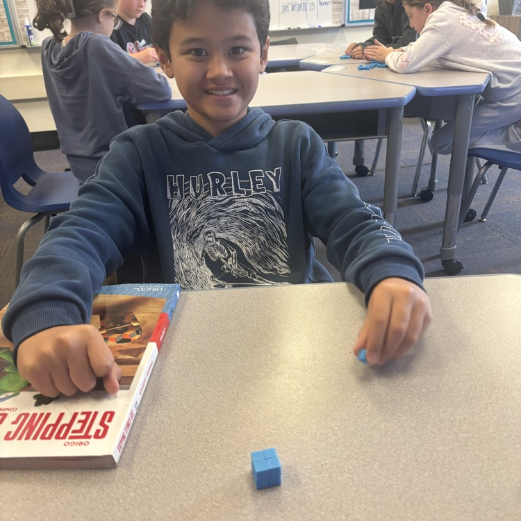 student showing 3 dimensional block he made  to explore the concept of area
