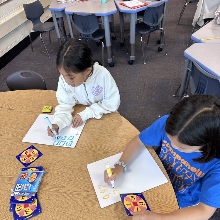 two girls with whiteboard playing the game  of  24
