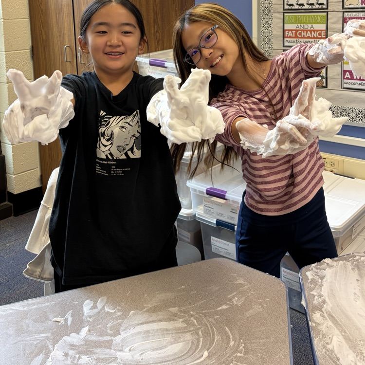 two girls holding up peace signs with shaving cream 
