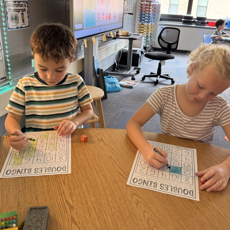two students working on a doubles worksheet 