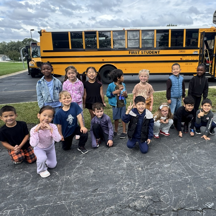 Kindergarten class in front of a bus. 