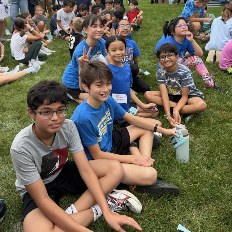 6th grade students sitting on sideline 