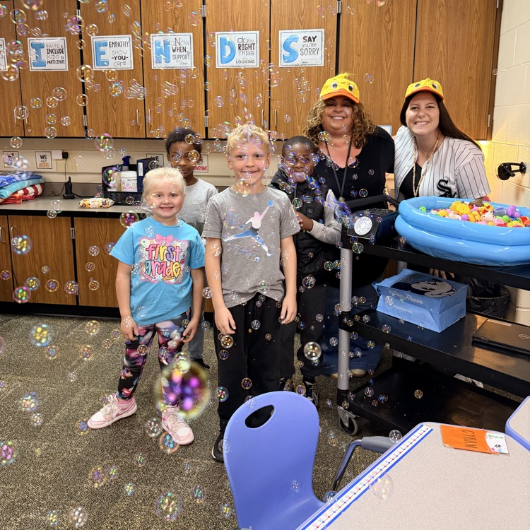 Students and teachers with bubbles and a pool of rubber ducks