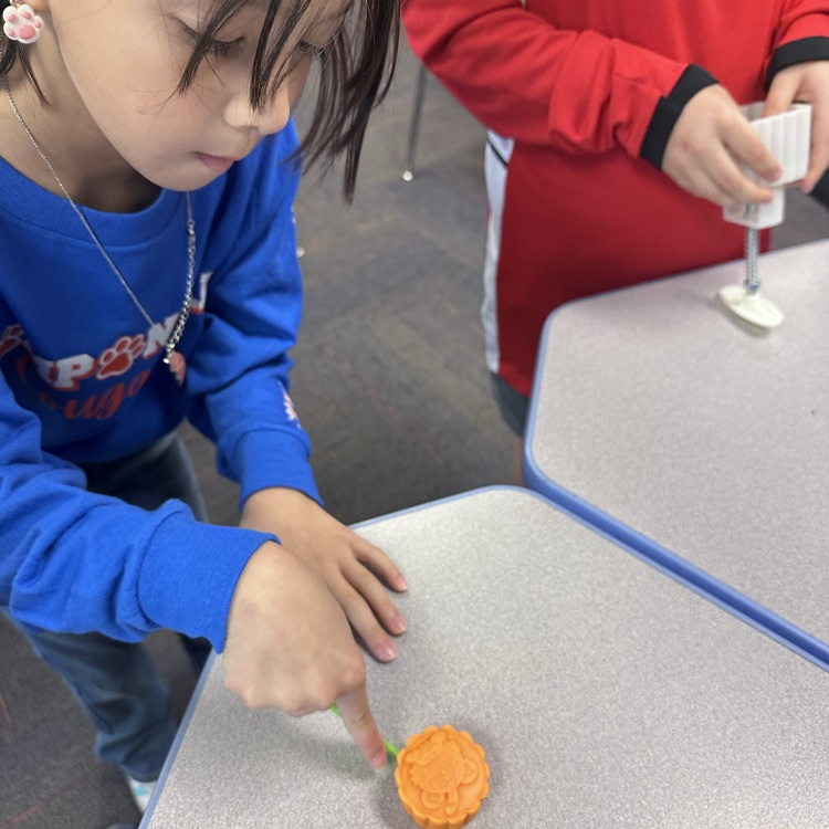 student picking up  a Play-Doh mooncake