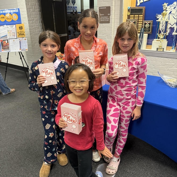students in their pajamas holding popcorn 