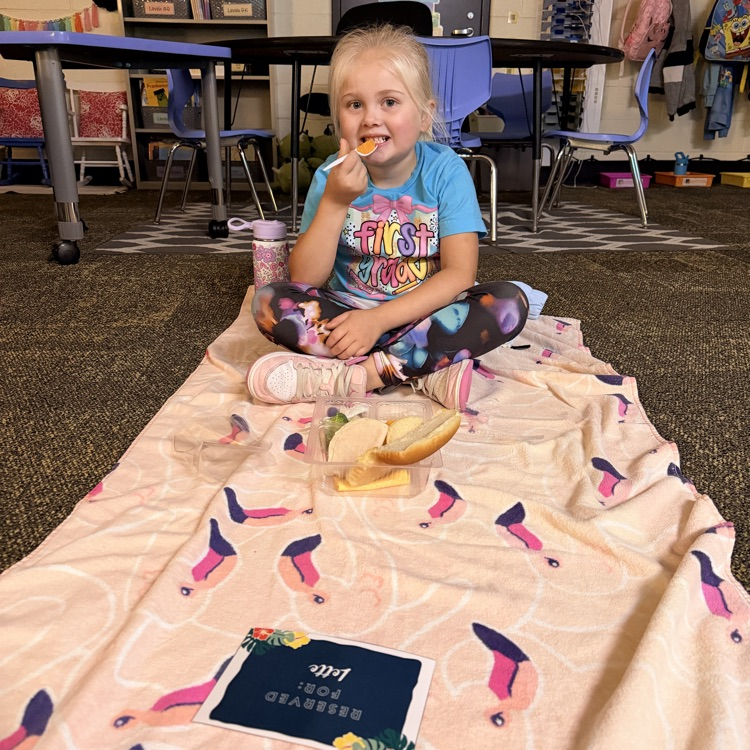Student eating lunch on a beach towel