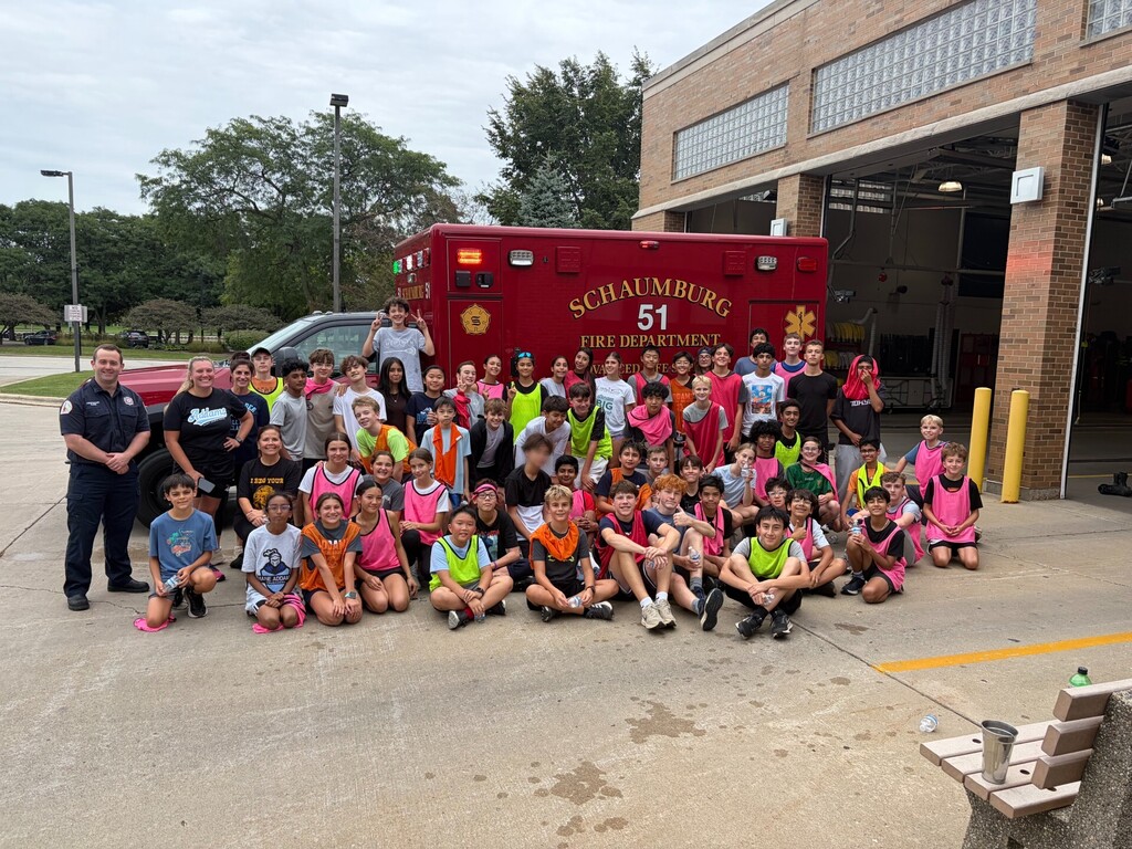 students posing outside a fire station