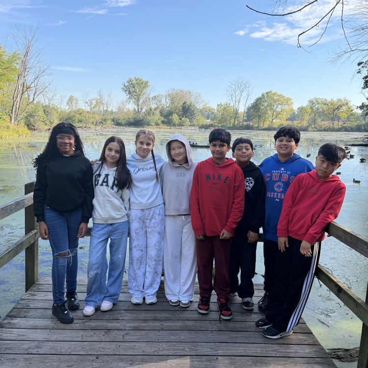 students standing in front of a pond