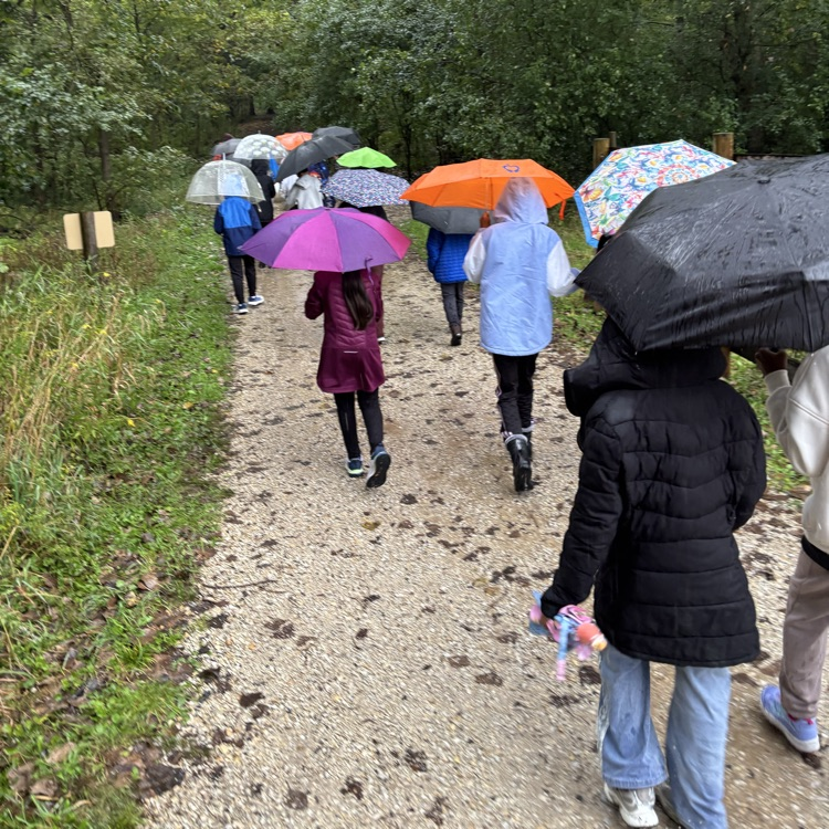 kids walking on a path with umbrella