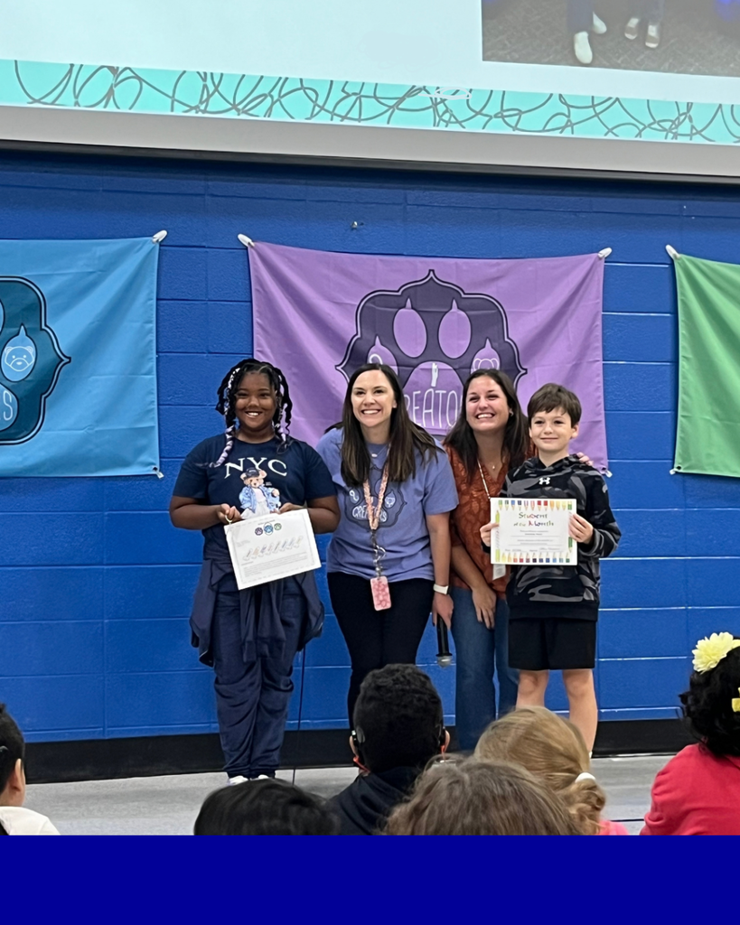 Students smiling with their award next to their teacher