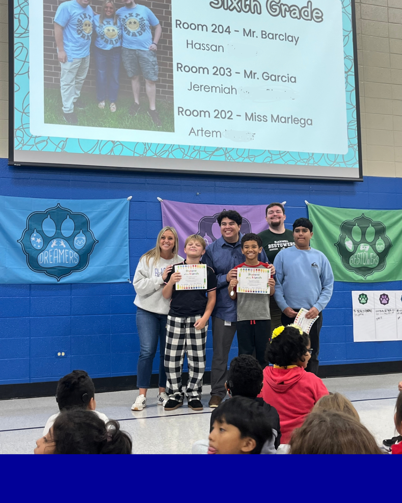 Students smiling with their award next to their teacher