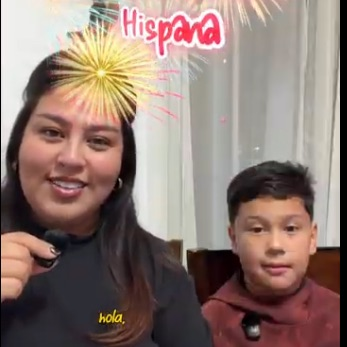 A 3rd grader and his mom in a video teaching the game Lotería and then allowing students to play in class.. prizes included!
