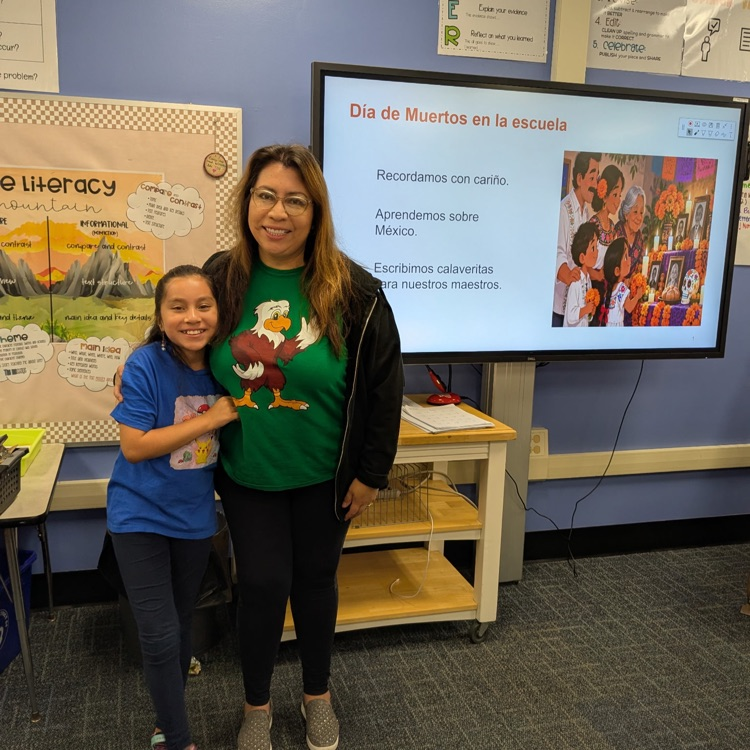 A 3rd grader with her mom after her presentation on Dia de Muetos.
