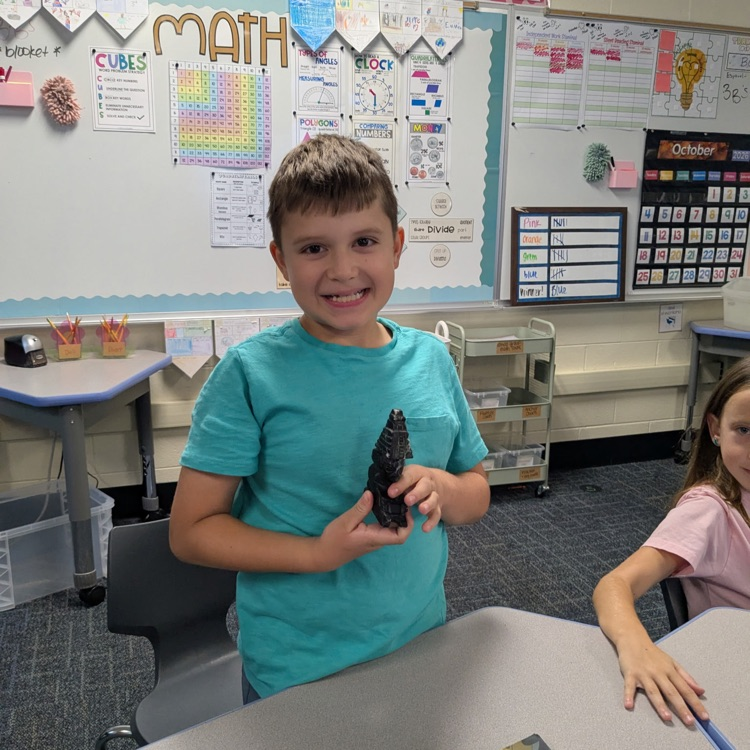 A 3rd grader sharing a traditional item from Guatemala, brought in by his grandparents.