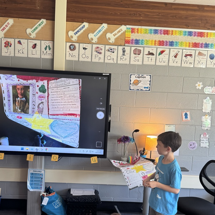 student sharing his star of the work poster with his class 