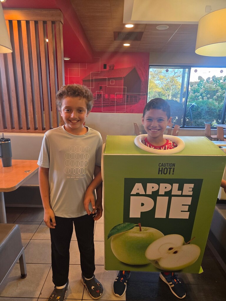 1 student standing next to another student in the McDonald's apple pie costume