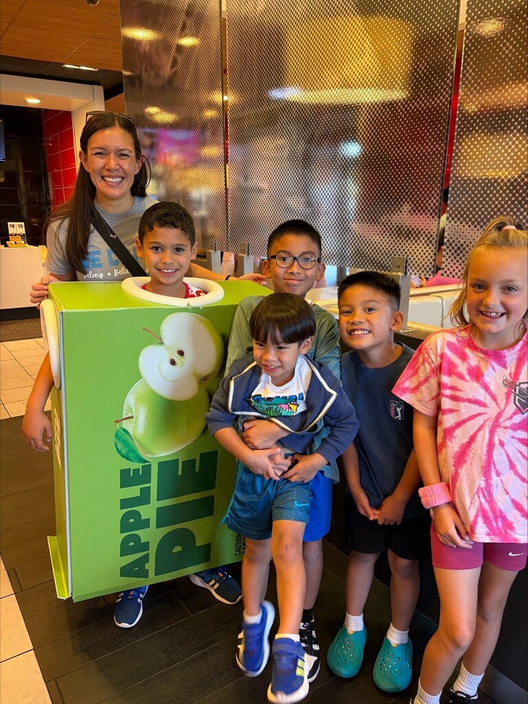 Dr. Houlihan standing with student in McDonald's apple pie costume and 4 other students