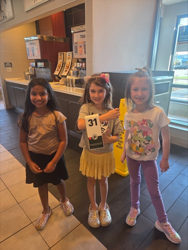 three girls holding their number for their order