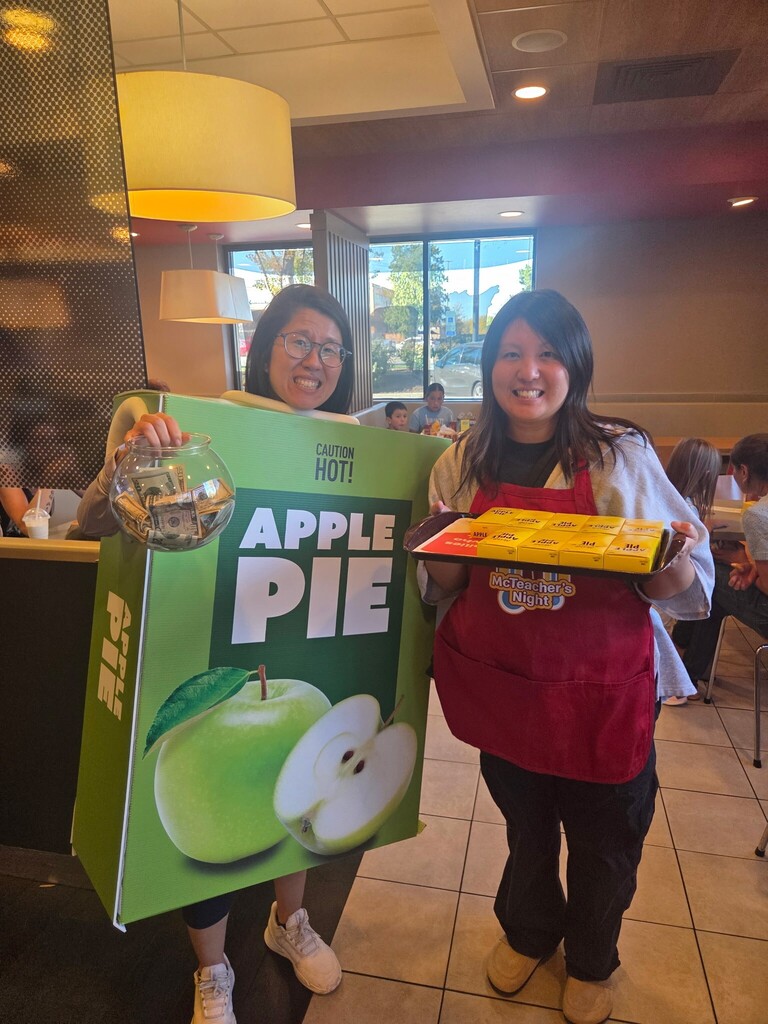 Ms. Shao in McDonald's applie pie costume with Mrs. Yu holding apple pies