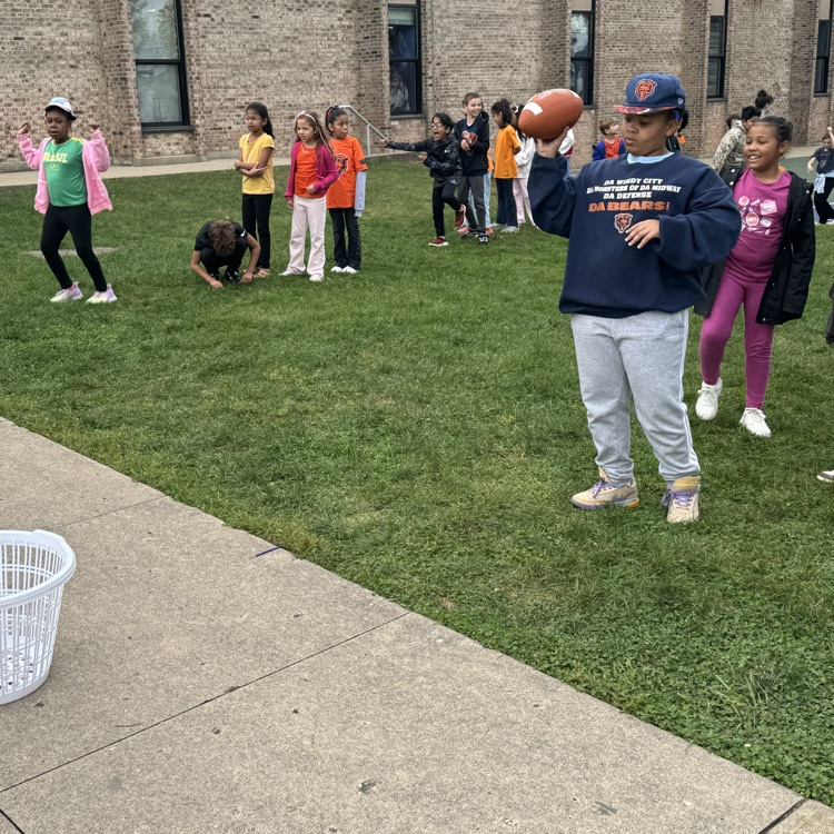 student throwing a football into a basket