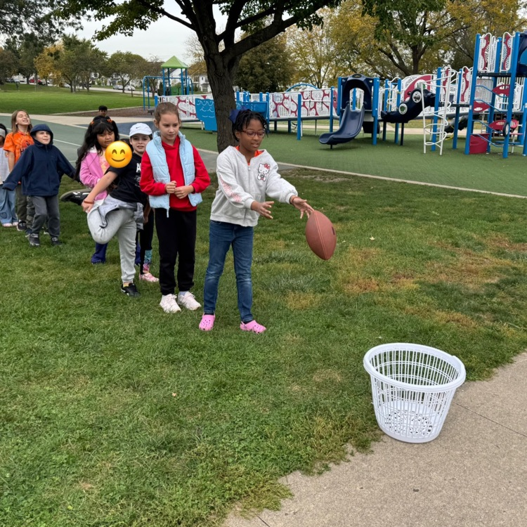 student throwing a football into a basket