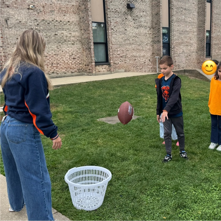 student throwing a football into a basket