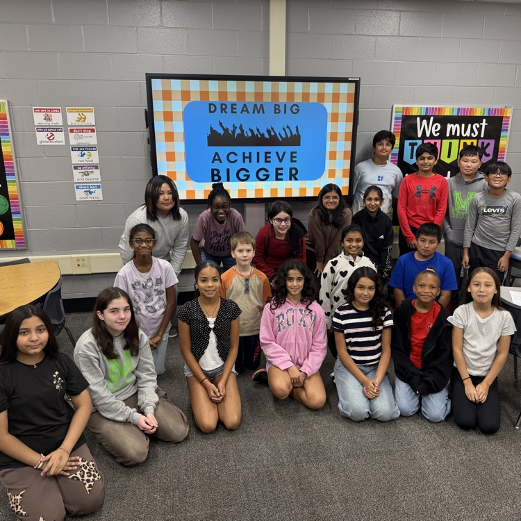 students sitting in front of a screen that says Dream Big, Achieve Bigger