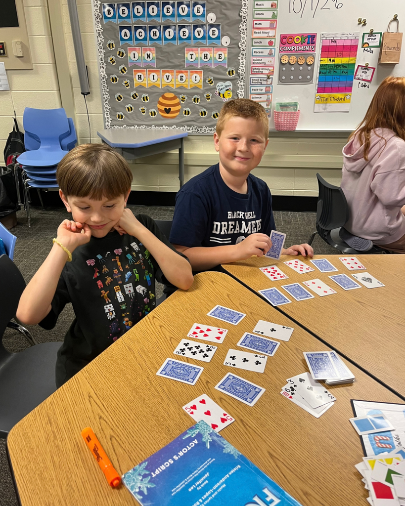 Students smiling while playing a card game