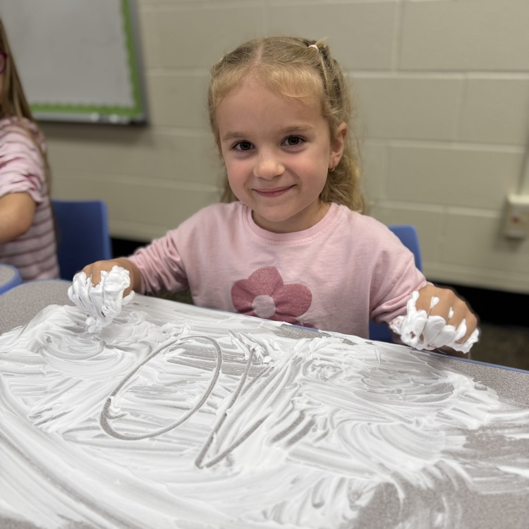 Student drawing a number in shaving cream on a desk