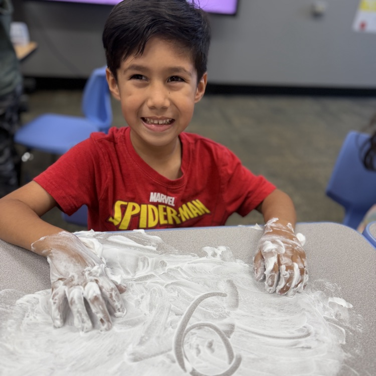 Student drawing a number in shaving cream on a desk