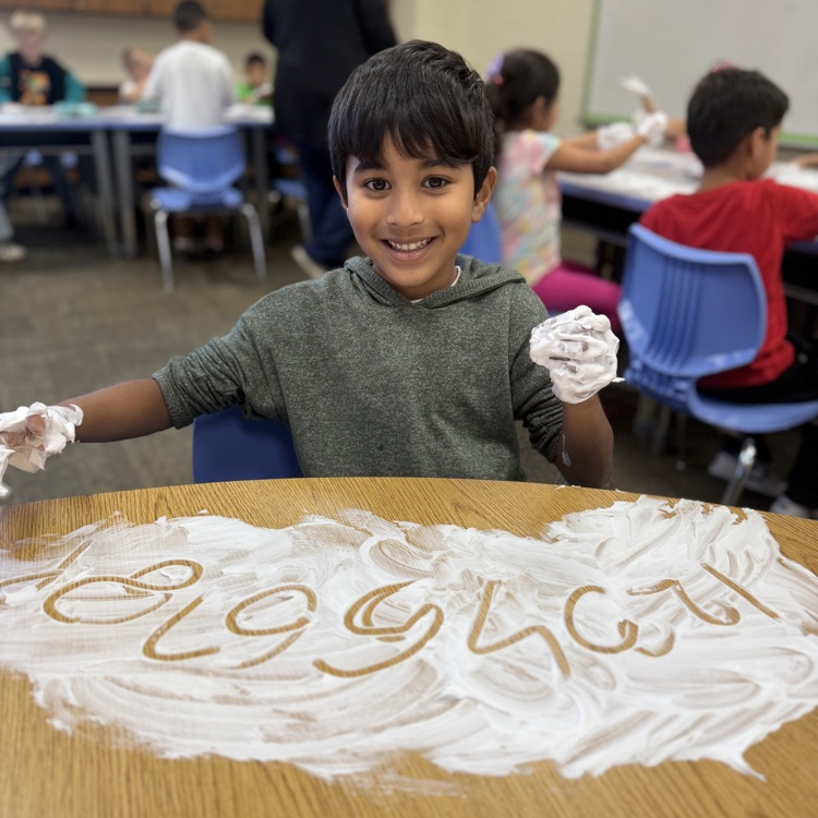 Student drawing a number in shaving cream on a desk