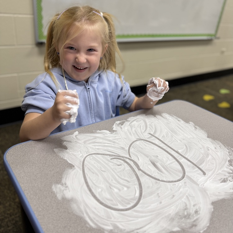 Student drawing a number in shaving cream on a desk