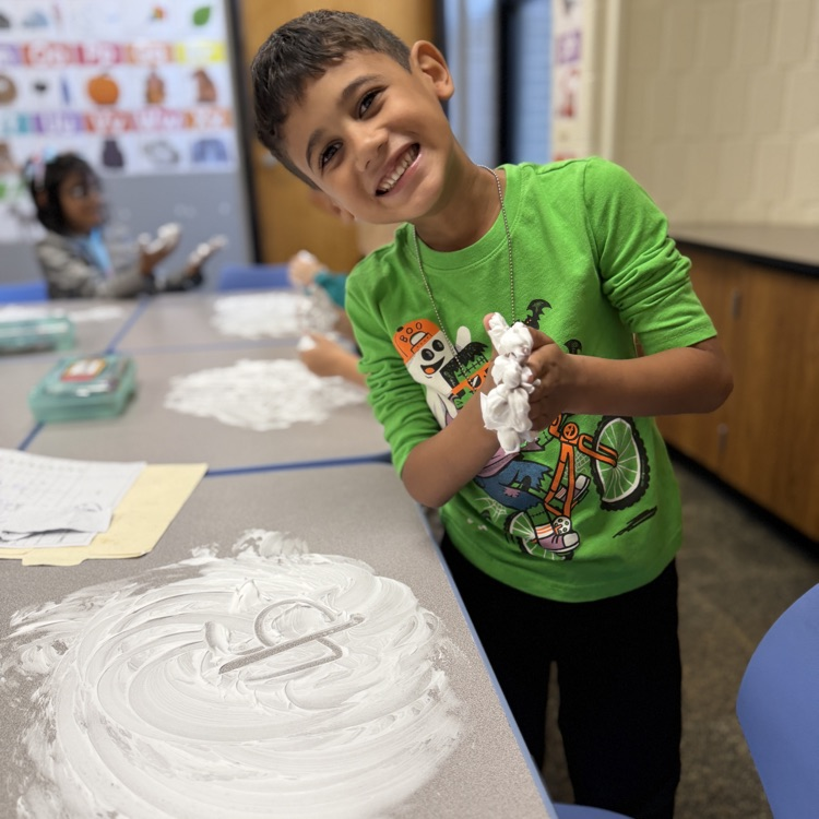 Student drawing a number in shaving cream on a desk