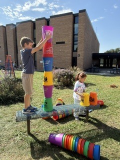 students stacking large cups