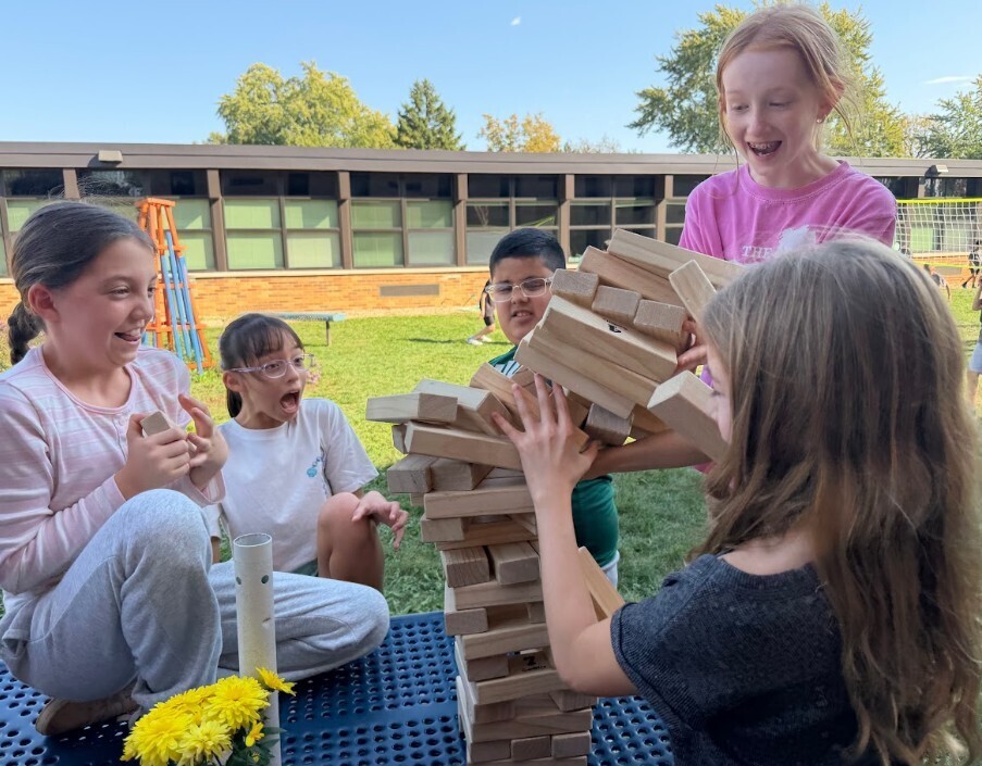 students laughing at the Jenga blocks falling