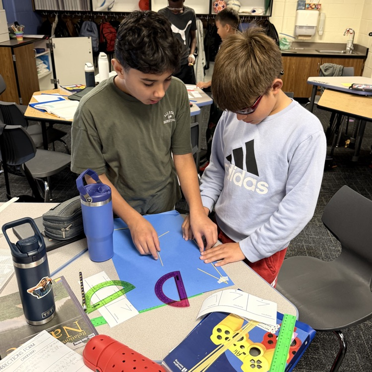 2 6th Graders using noodles to make triangle. 