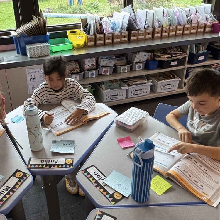 two students working on problems in math book