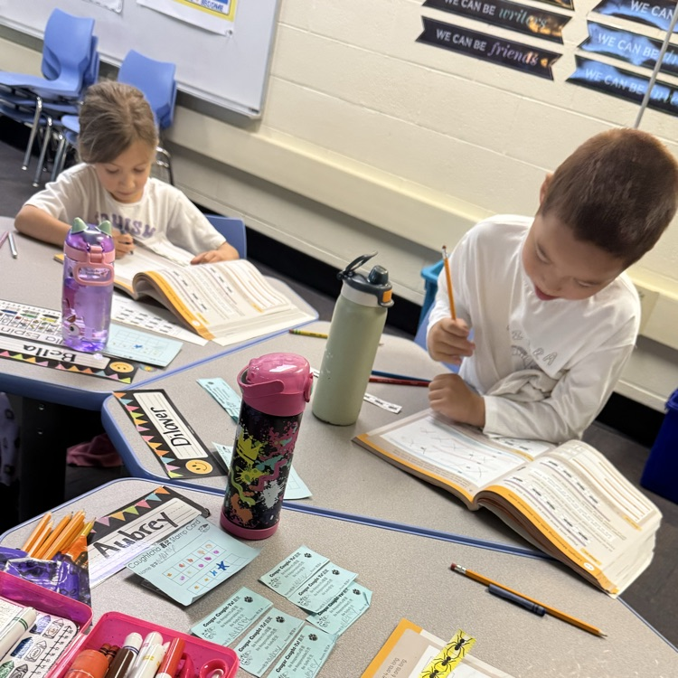 two students working on problems in math book